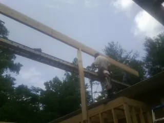Carpenter setting a ridge beam over a new addition frame — Ice Dam Removal by Roofing Brothers in Palo