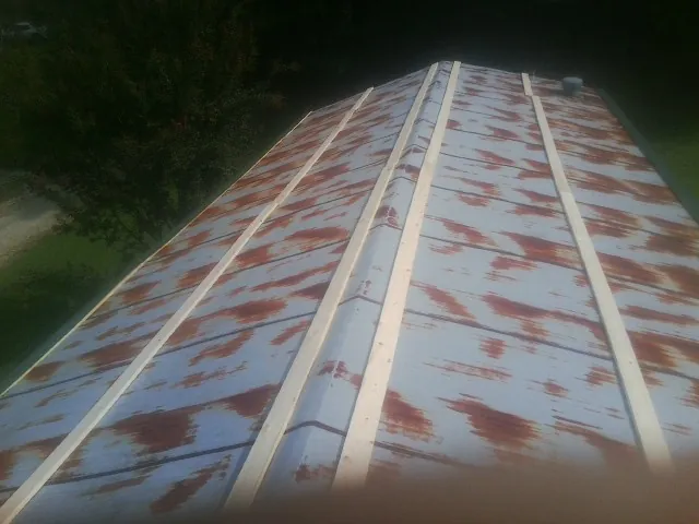 Rusted metal roof panels with new wood purlins before replacement — Storm Damage Roof Repair in Palo by Roofing Brothers