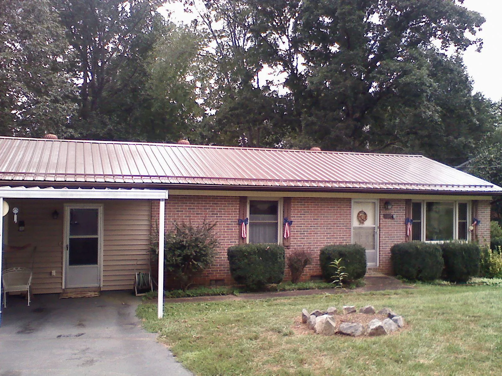 Bronze metal roof and carport on a brick ranch home — Roof Repair work by our crew in Palo