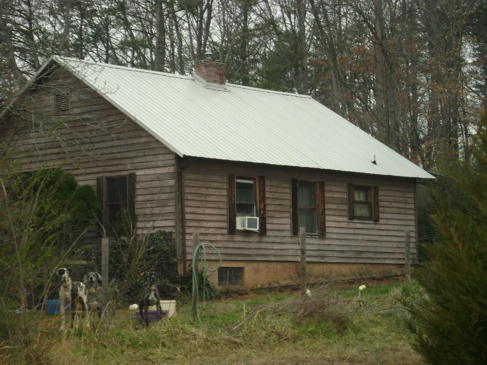 White metal roof on an old wood sided farmhouse, from a Metal Roof Installation job in Palo